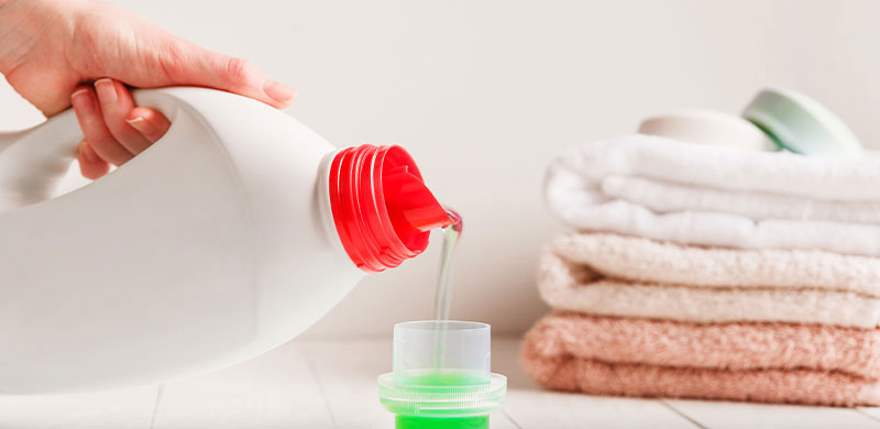 detergent gel being poured into cup for laundry