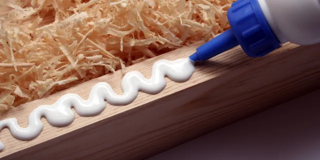 image of bottle of wood glue being squeezed onto the edge of a piece of wood
